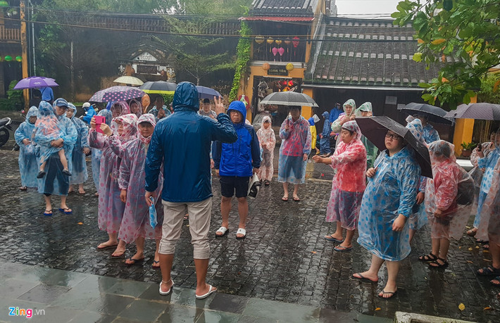 Trên hình là một nam hướng dẫn viên đang giới thiệu do nhóm du khách nước ngoài khi đến tham quan phố cổ Hội An.
