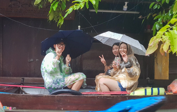 Nhóm du khách Hàn Quốc chọn cách đi thuyền ngắm nước lũ tại phố cổ, họ tranh thủ khoảnh khắc đặc biệt này để lưu lại kỷ niệm khi đến với phố cổ Hội An.