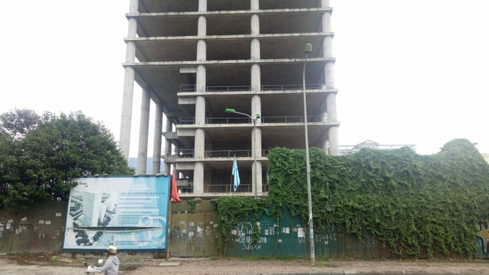 Sau nhiều năm bỏ hoang, cỏ mọc um tùm xung quanh toà tháp cao tầng Vicem Tower. Ảnh: SKCĐ.