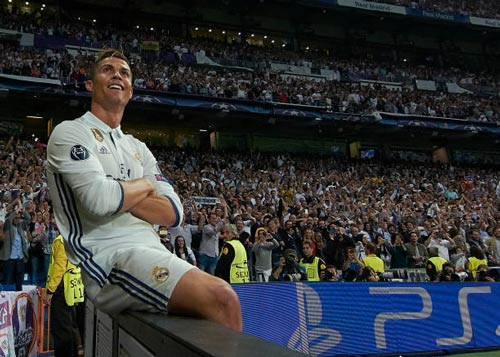 “Yên vị trên ngai vàng” – Ronaldo an tọa sau khi lập cú hat-trick mới nhất tung lưới Atletico, với các “thần dân” Madridista đang ở phía sau tán thưởng, chúc tụng. Ảnh: Getty Images