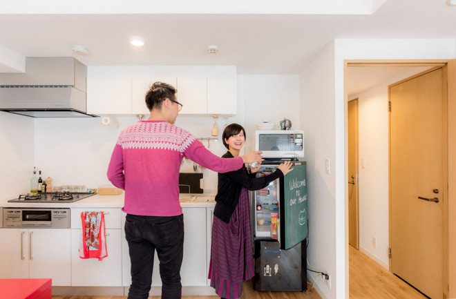 Khu vực bếp sử dụng gam màu trắng sáng sủa, các vật dụng đều được sắp xếp gọn gàng với tủ bếp gắn lên trần và tường nhà để tăng diện tích lưu trữ.