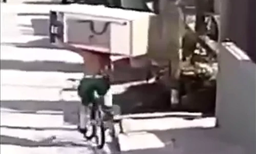 Người đàn ông vác tủ lạnh lên vai, vận chuyển bằng xe đạp