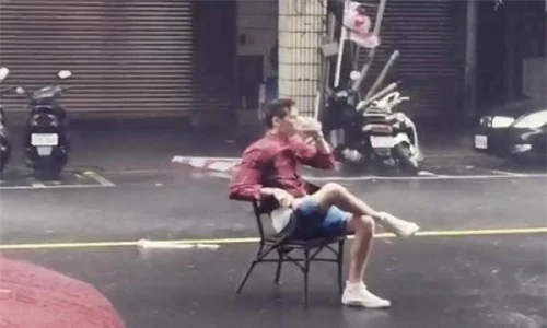 Thản nhiên đọc báo, uống trà trong siêu bão giữa đường phố