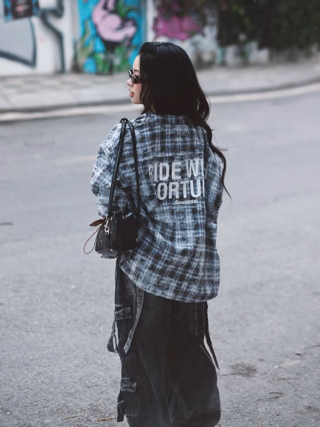 Chiếc áo sơ mi kẻ caro khoác hờ bên ngoài cùng quần denim ống rộng cạp trễ không chỉ tạo nên vẻ ngoài bụi bặm, cá tính mà còn khéo léo khoe được vòng eo phẳng lì - niềm mơ ước của biết bao bà mẹ bỉm sữa. (Ảnh: IGNV)