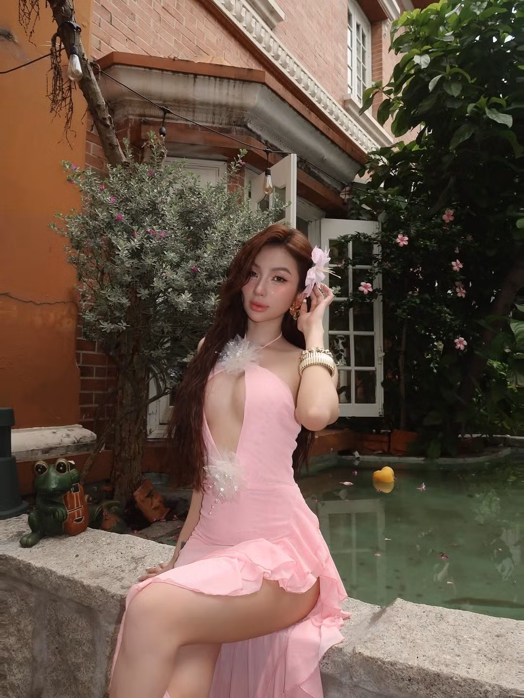 Phần cổ yếm cùng những lớp bèo nhún mềm mại bất đối xứng tạo nên sự bay bổng, lãng mạn, đồng thời tăng thêm vẻ quyến rũ cho trang phục.