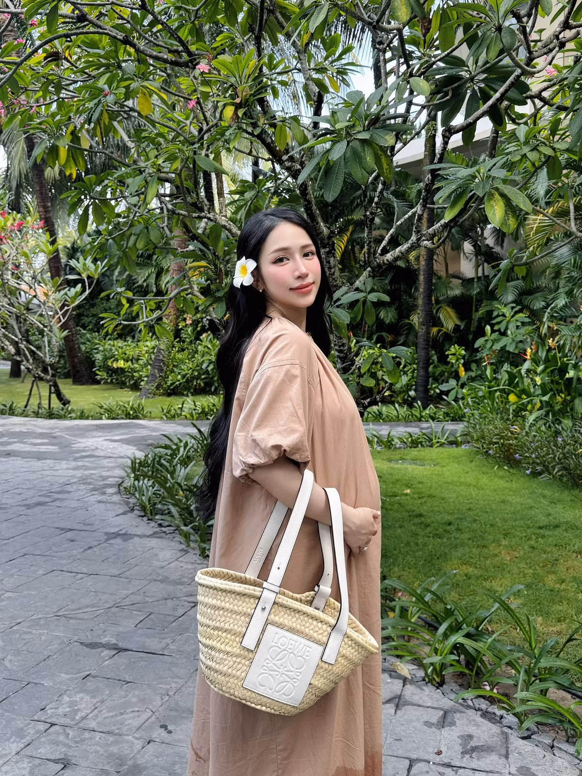 Bên cạnh những thiết kế khá "bánh bèo", cô nàng cũng lựa chọn lối lên đồ nhã nhặn, giản đơn. Chiếc váy maxi dáng suông màu be nhã nhặn, phối cùng túi cói Loewe thời thượng, mang đến sự thoải mái nhưng không kém phần sang trọng.