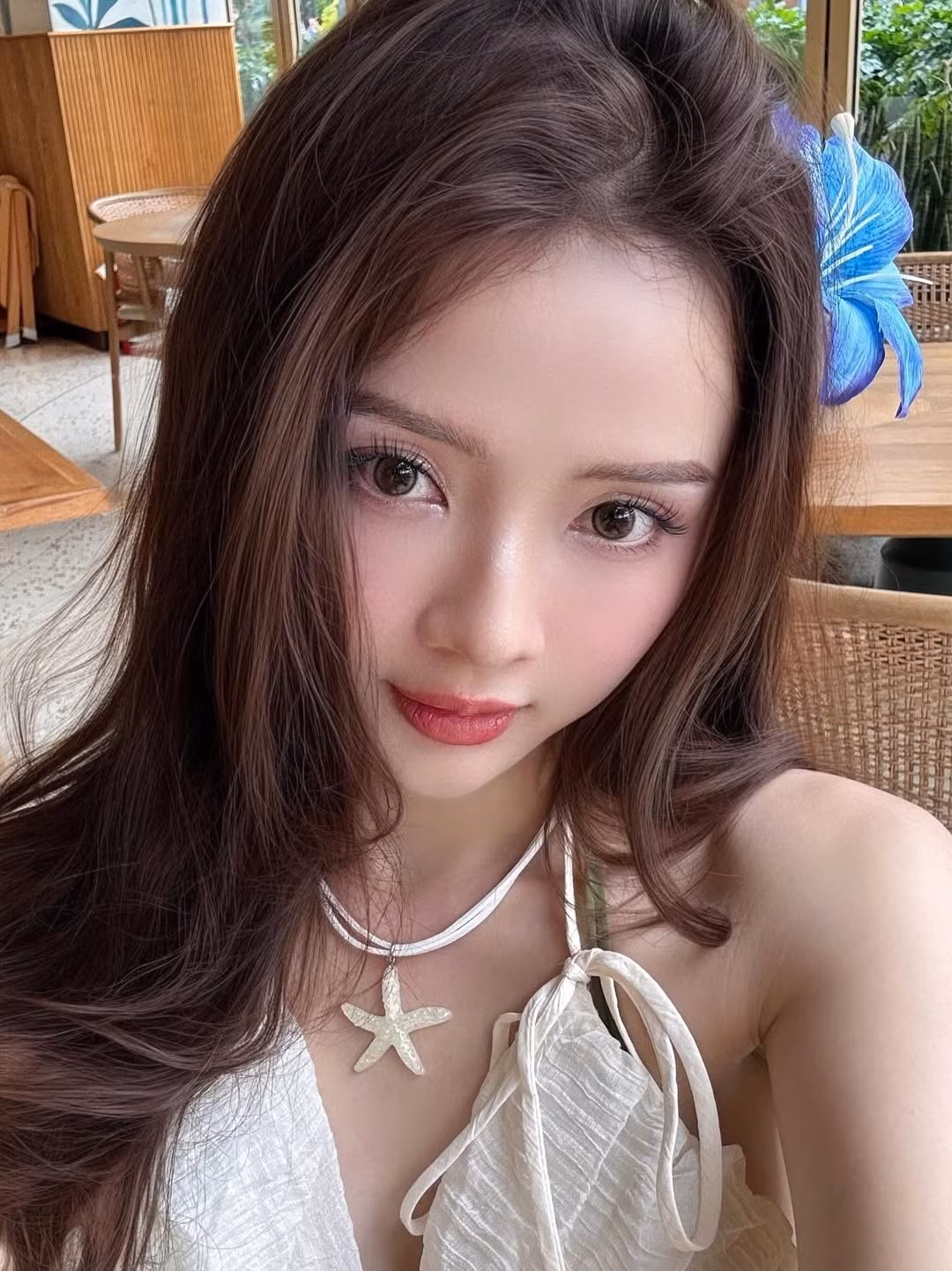 Điểm xuyết cho tổng thể là những phụ kiện tinh tế như vòng cổ hình ngôi sao biển và bông hoa xanh cài trên tóc, mang đến vẻ đẹp dịu dàng, gần gũi với thiên nhiên. (Ảnh: IGNV)