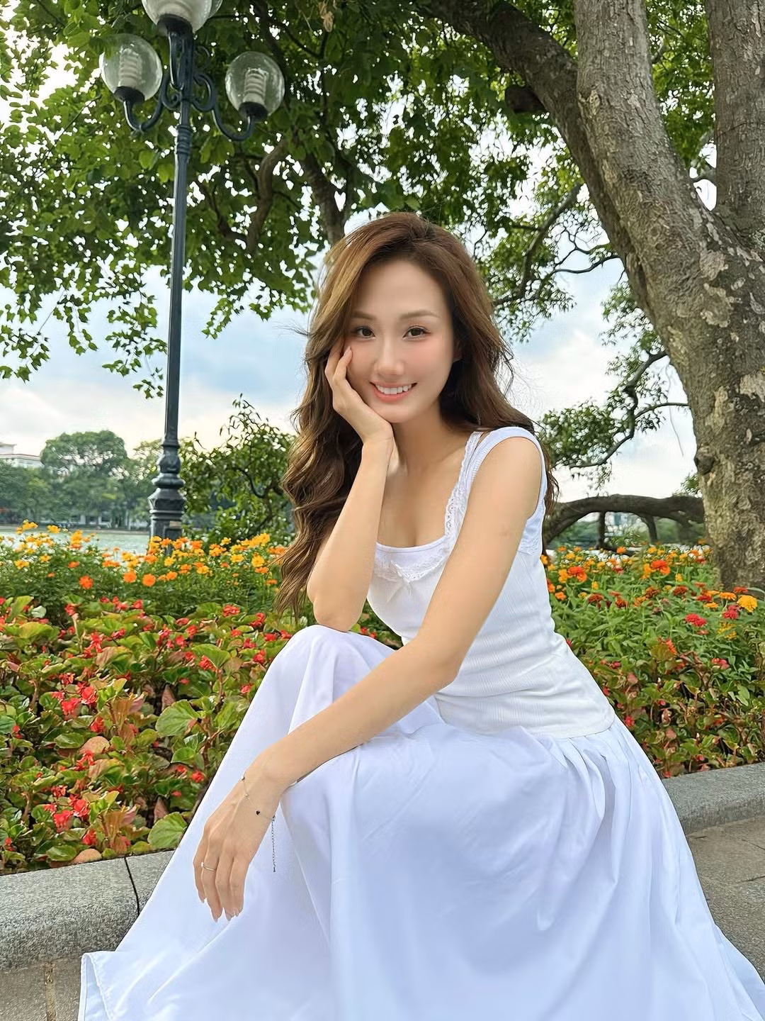 Dù là những bức ảnh chụp cận mặt với ánh nắng rực rỡ, hay những khoảnh khắc trầm tư, thả dáng bên hồ, vẻ đẹp mong manh và đầy sức sống của Hoàng Khánh Ly đều làm say đắm lòng người. (Ảnh: FBNV)