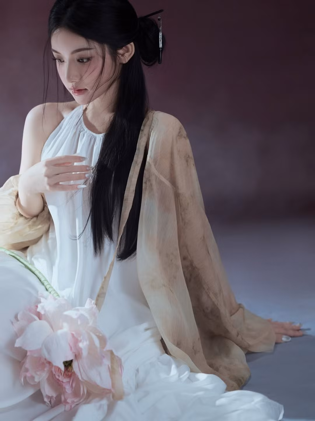 Chi tiết đóa hoa sen hồng cầm trên tay kết hợp cùng lối trang điểm trong veo giúp tôn lên làn da trắng mịn và gương mặt "búp bê" đặc trưng. (Ảnh: IGNV)