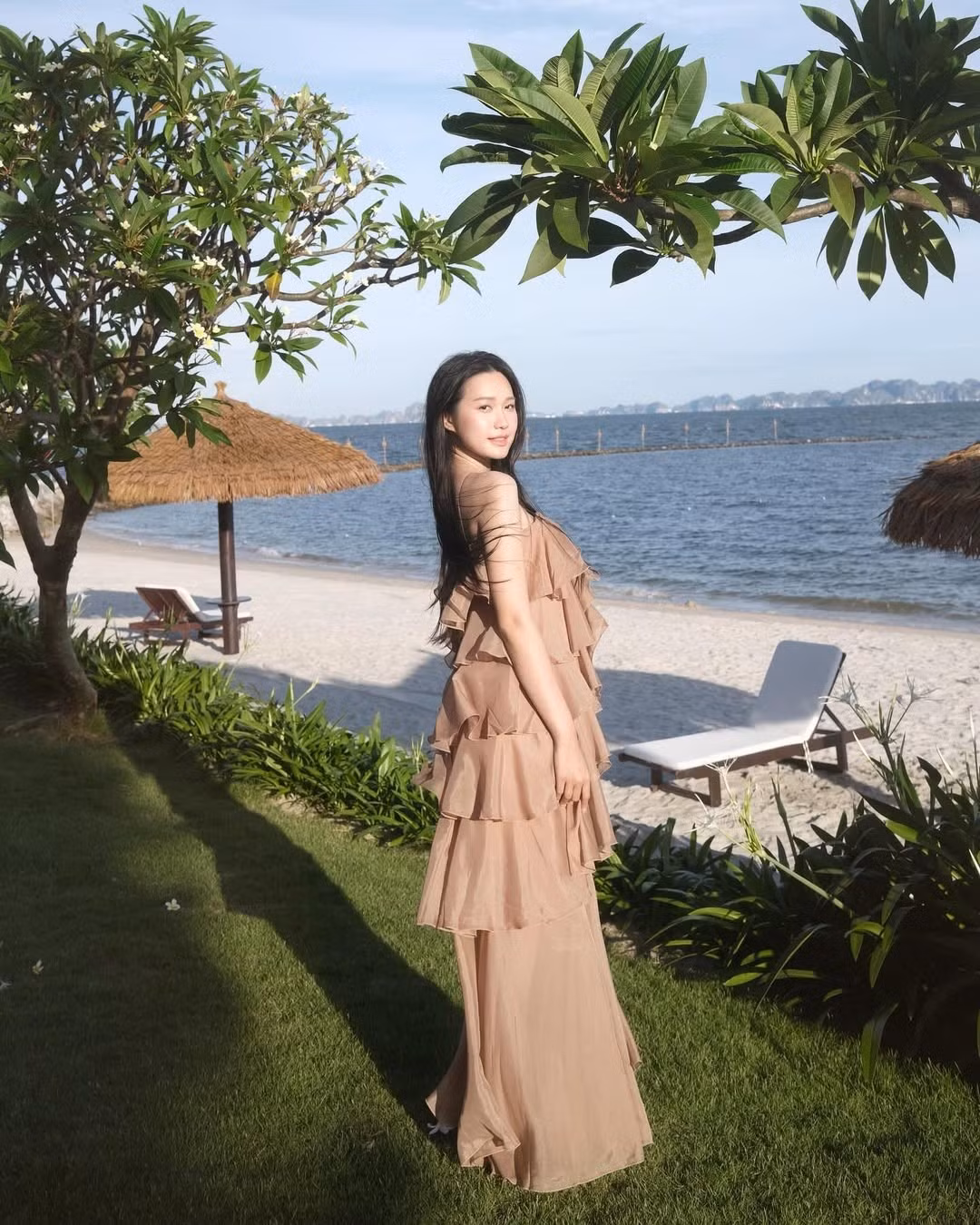 Background là bãi cát trắng mịn, hàng cây xanh mát và mặt biển trong xanh càng tôn lên vẻ đẹp thoát tục của nàng WAGs đình đám này.