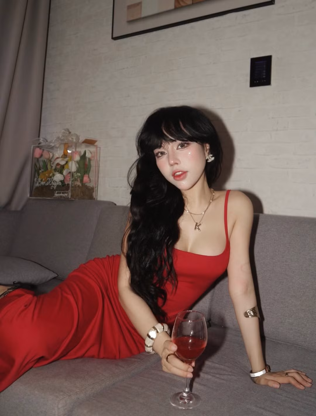 Những tư thế tạo dáng bên ly rượu vang trên chiếc sofa xám càng làm tôn lên vẻ sang trọng, có chút bí ẩn và lãng mạn. Bảo Khuyên Susan thể hiện khả năng diễn xuất trước ống kính đầy chuyên nghiệp, biến những bức ảnh "sống ảo" trở nên có hồn và đậm chất nghệ thuật. (Ảnh: IGNV)