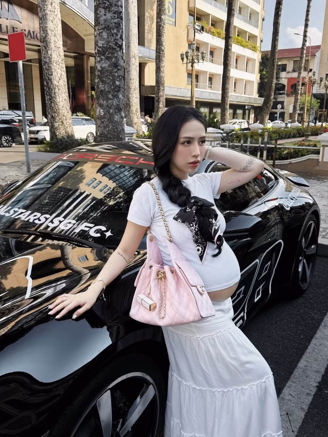 Kết hợp với áo là chiếc váy maxi màu trắng dáng dài với các tầng xếp ly bồng bềnh, tạo nên một tổng thể vừa thoải mái, vừa thanh lịch và bay bổng.