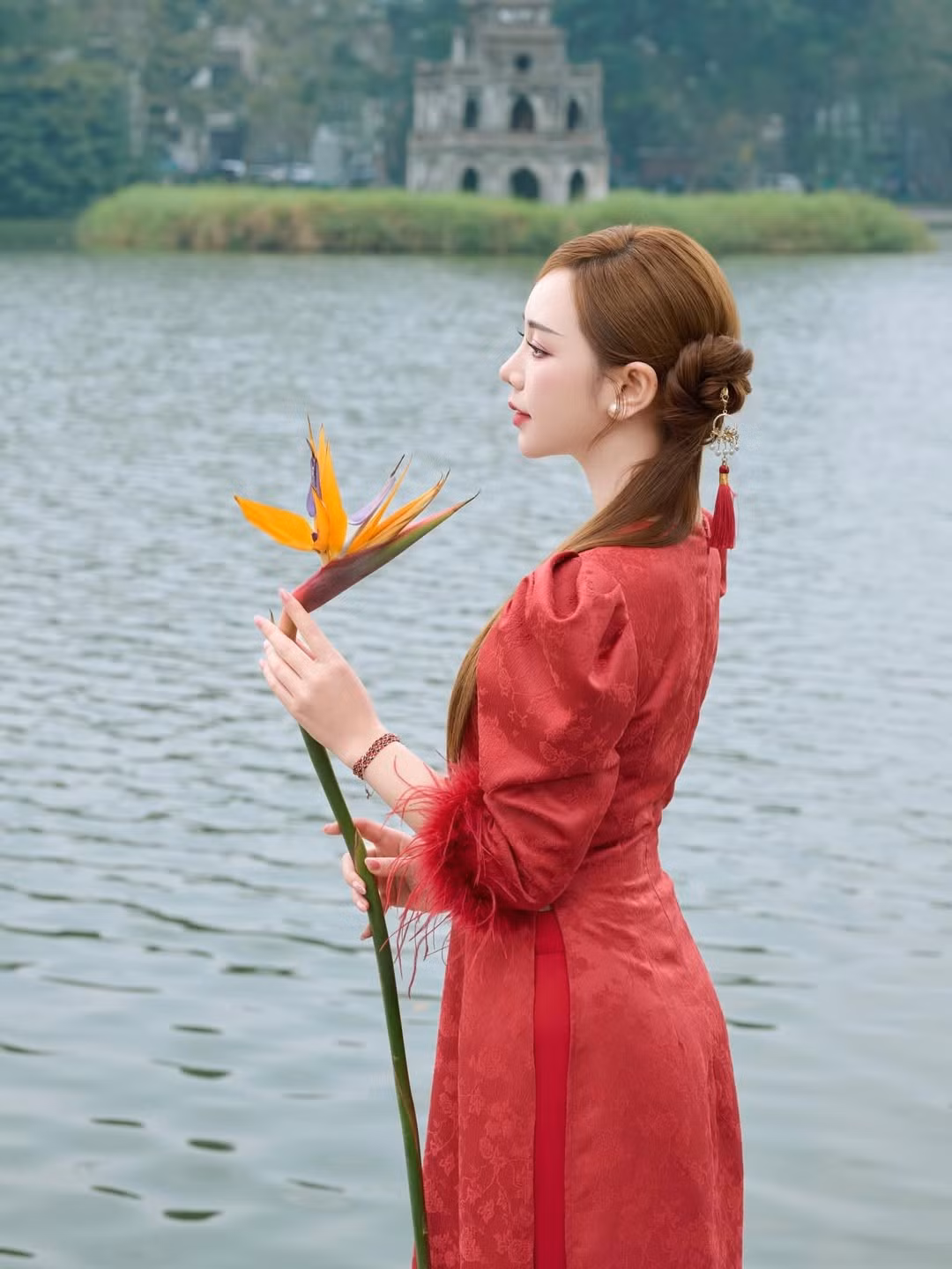 Bộ ảnh được thực hiện tại Hồ Gươm - một trong những biểu tượng lịch sử và văn hóa của Hà Nội. Sự kết hợp giữa vẻ đẹp cổ kính, trầm mặc của Tháp Rùa và mặt nước hồ xanh biếc đã tạo nên phông nền hoàn hảo cho tà áo dài truyền thống. (Ảnh: IGNV)