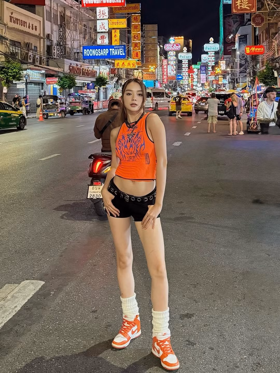 Cô nàng phối cùng quần short đen cạp trễ sành điệu, tô điểm thêm bằng chi tiết đai hông cá tính.