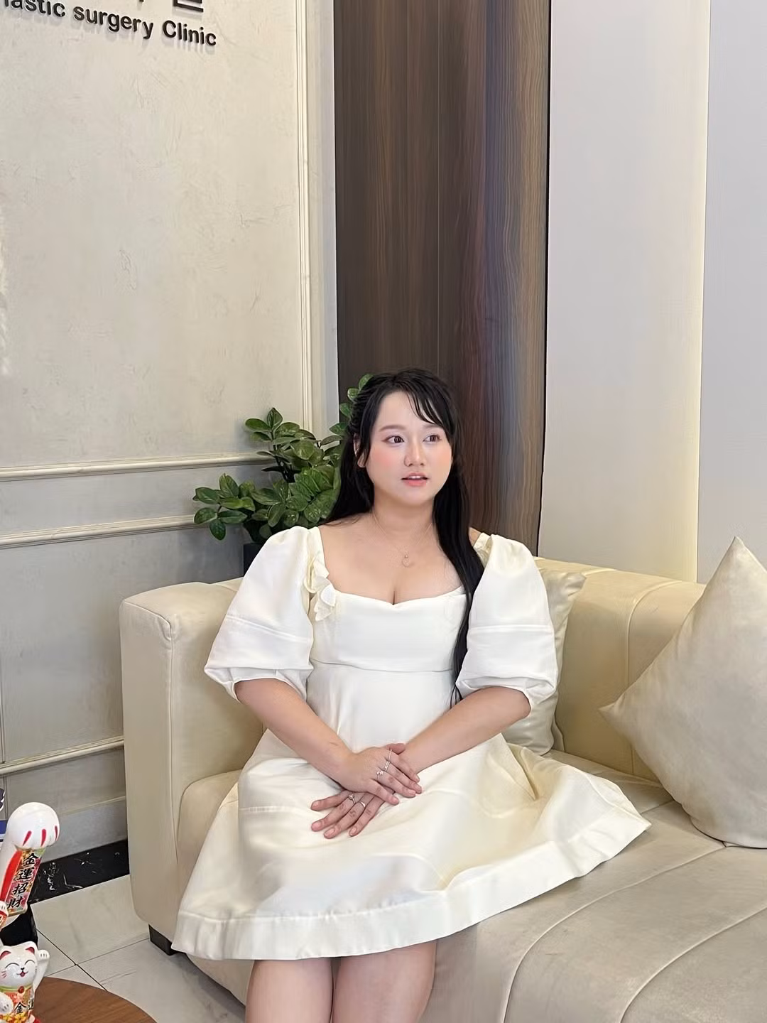 Gương mặt bầu bĩnh với đôi mắt to tròn, long lanh và nụ cười tươi tắn càng thêm phần rạng rỡ. Mái tóc đen dài được uốn xoăn nhẹ nhàng, buông xõa tự nhiên, tạo nên một tổng thể hài hòa và cuốn hút.