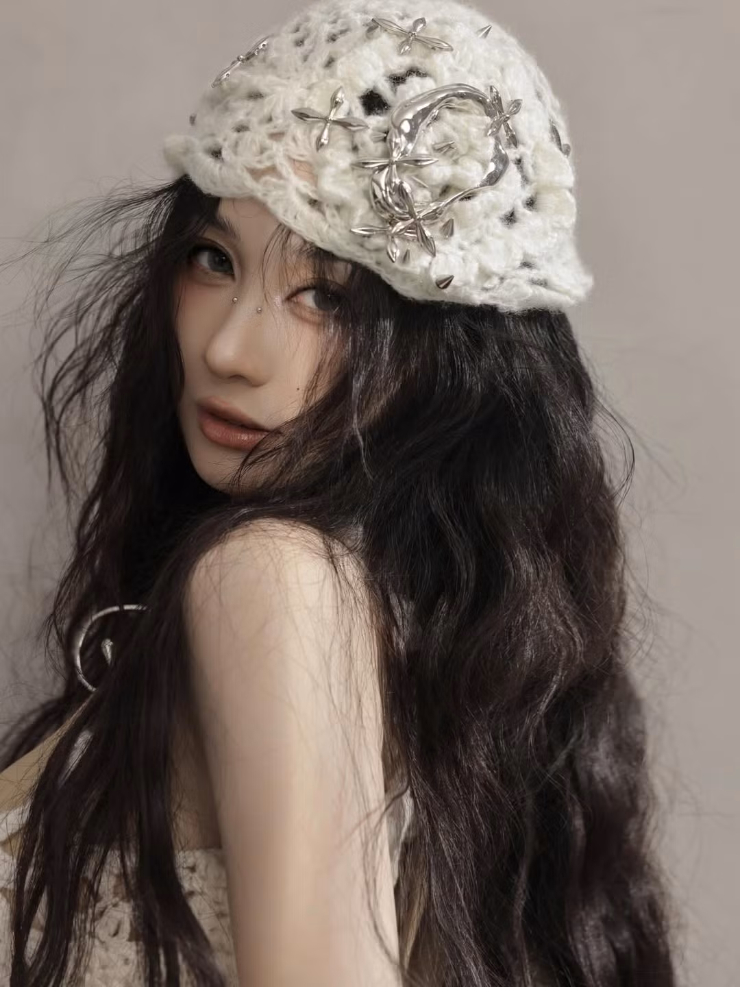 Điểm nhấn nổi bật là chiếc mũ len/móc beret đính kim loại cỡ lớn và chuỗi dây chuyền kim loại to bản, tạo nên tổng thể đầy cuốn hút. (Ảnh: IGNV)
