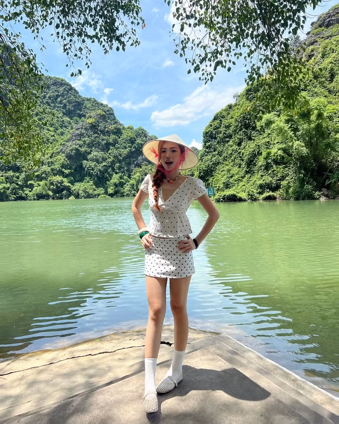 Đặc biệt, chiếc nón lá truyền thống được điểm xuyết thêm dải ruy băng hồng bay bổng, cùng mái tóc tết gọn gàng, đã tạo nên một tổng thể vừa hiện đại vừa mang đậm nét truyền thống, vô cùng ăn ảnh.