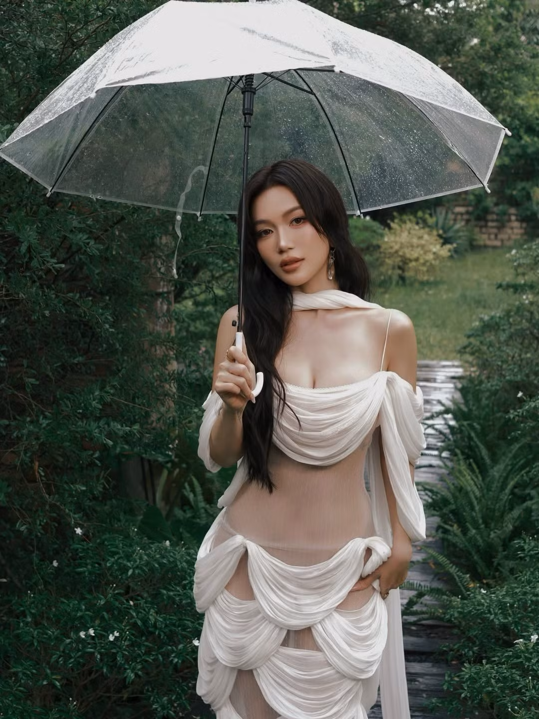 Chiếc ô trong suốt không chỉ là đạo cụ mà còn tăng thêm nét lãng mạn, mơ màng cho tổng thể. (Ảnh: IGNV)