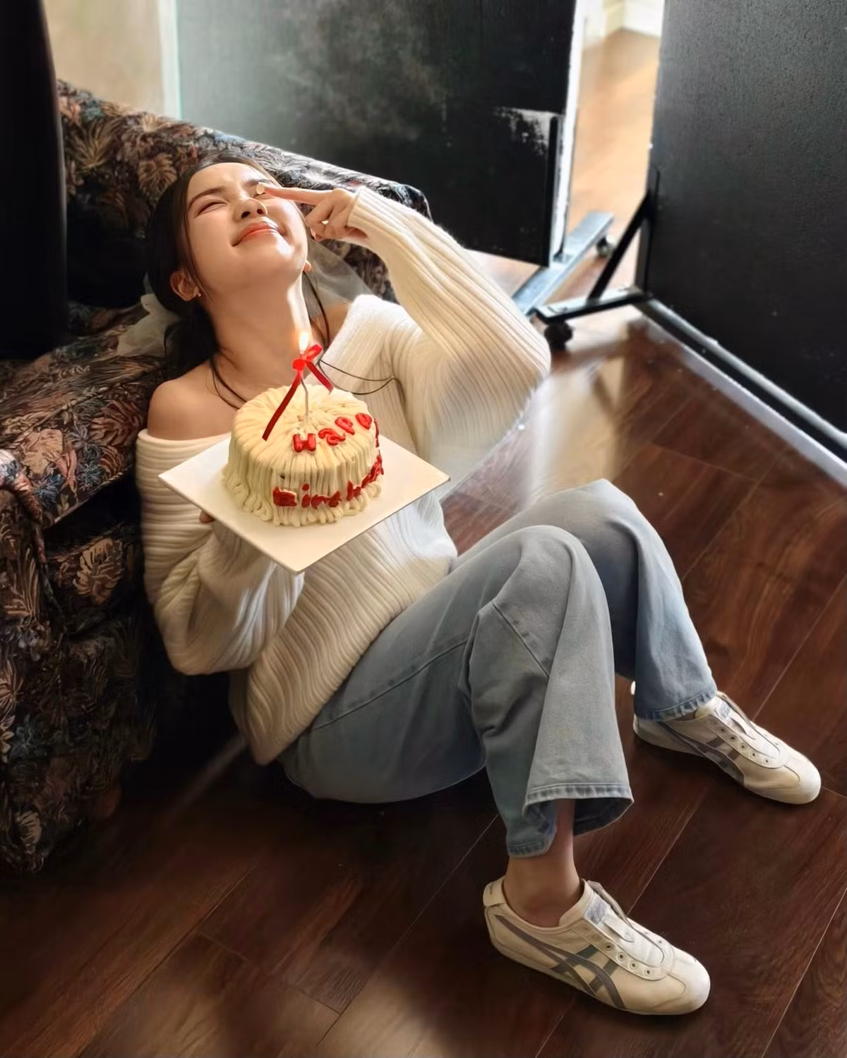 Điểm nhấn đáng yêu của bộ ảnh chính là chiếc mũ sinh nhật bằng ren trắng điệu đà và chiếc bánh kem nhỏ xinh với dòng chữ "Happy Birthday" đỏ rực. (Ảnh: FBNV)