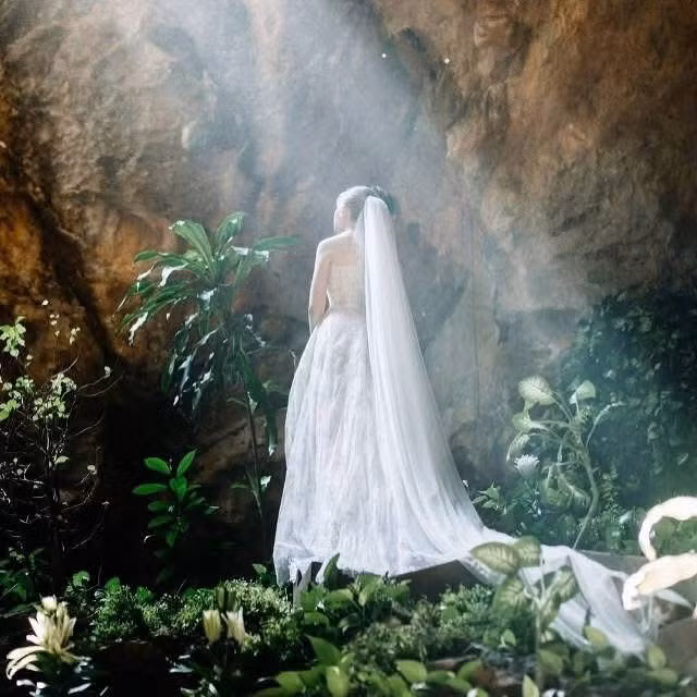 Ánh sáng tự nhiên từ cửa hang rọi xuống hay luồng sáng ấm áp từ đèn chiếu tạo nên hiệu ứng lung linh, huyền ảo, làm nổi bật khoảnh khắc trao lời thề nguyện của cô dâu, chú rể. (Ảnh: Niên và Katia)