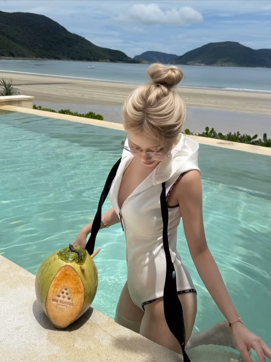 Trong loạt ảnh, Lê Huyền Diệu khoe vóc dáng quyến rũ trong bộ đồ bơi phối cùng áo khoác mỏng màu trắng. (Ảnh: FBNV)