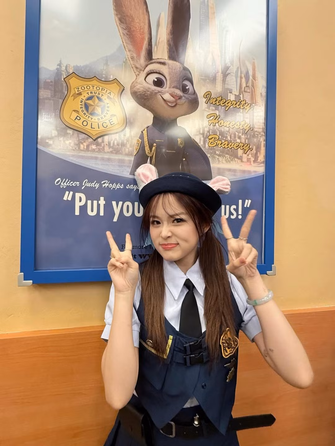Trong bộ ảnh, Chao xuất hiện trong bộ trang phục cảnh sát quen thuộc của Judy Hopps với áo sơ mi xanh nhạt, cà vạt đen, áo gile vest màu xanh đậm và chân váy xòe ngắn. Chiếc mũ beret cảnh sát cùng với đôi tai thỏ màu hồng trắng được cài khéo léo phía trên, tạo nên vẻ ngoài vừa ngây thơ vừa năng động. (Ảnh: IGNV)
