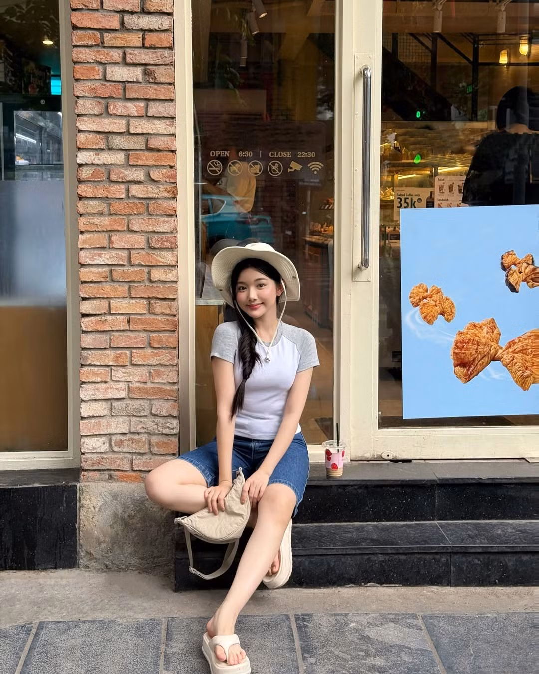 Tạo dáng trước tiệm bánh ngập ánh sáng vàng, tay cầm ly trà sữa, tóc tết lệch sang một bên, Quỳnh Trương không cố gắng tỏ ra "gợi cảm" hay "cool ngầu".