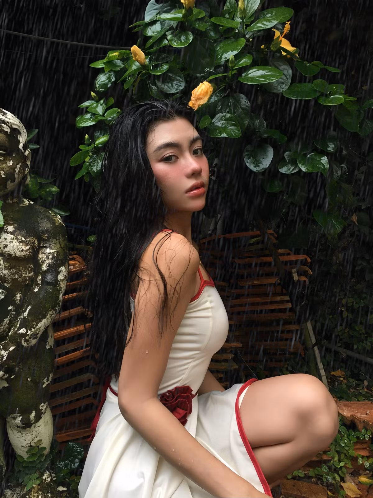 Trong loạt ảnh, Bảo Nghi xuất hiện trong một khu vườn ngập tràn cây xanh. Điểm đặc biệt là bối cảnh chụp diễn ra dưới trời mưa, tạo nên một không khí vừa mơ màng, lãng mạn lại vừa đầy táo bạo. (Ảnh: FBNV)