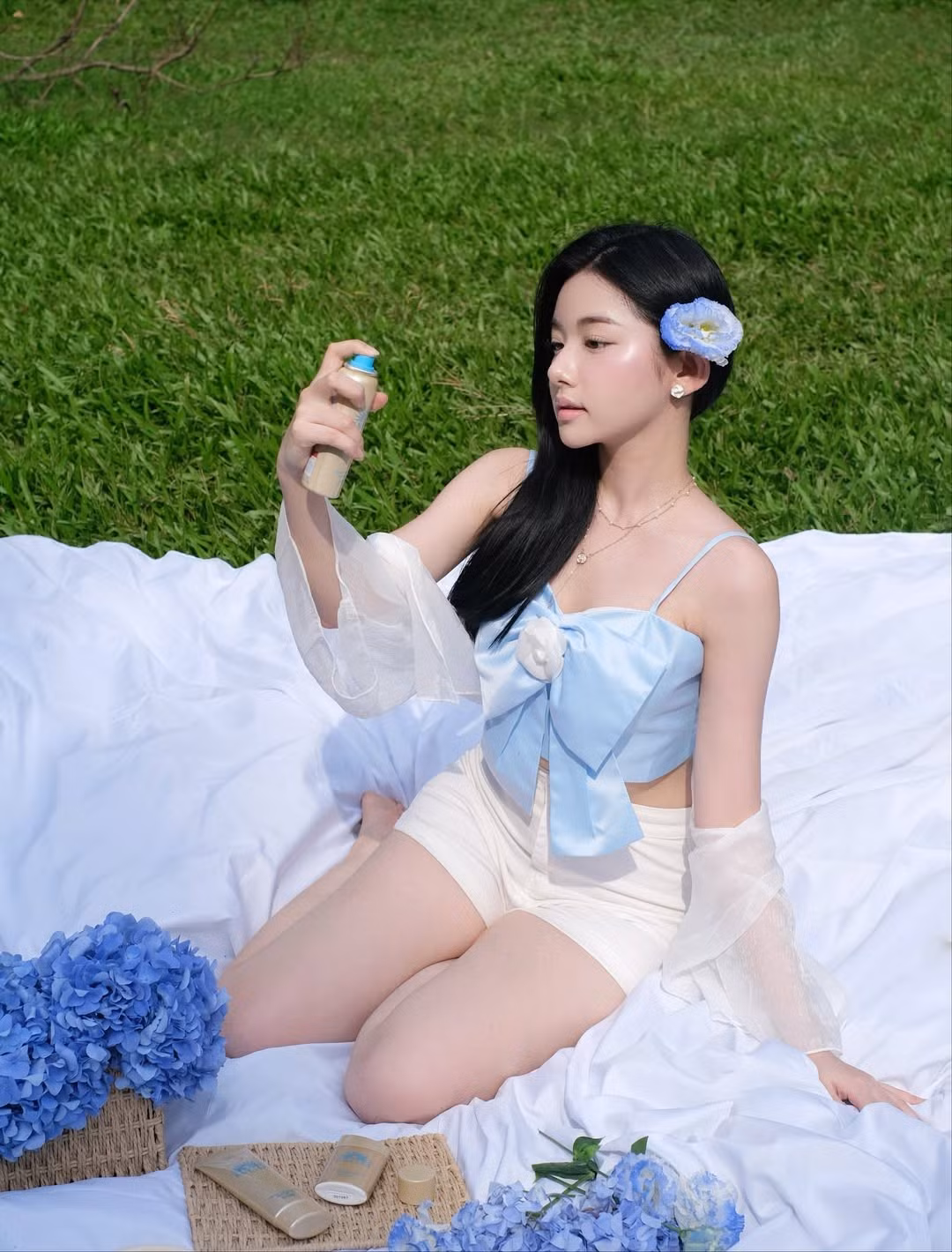 Điểm nhấn của bộ ảnh chính là những bó hoa cẩm tú cầu màu xanh biếc, đồng điệu với trang phục và mang đến cảm giác thanh thoát, mơ màng. (Ảnh: IGNV)