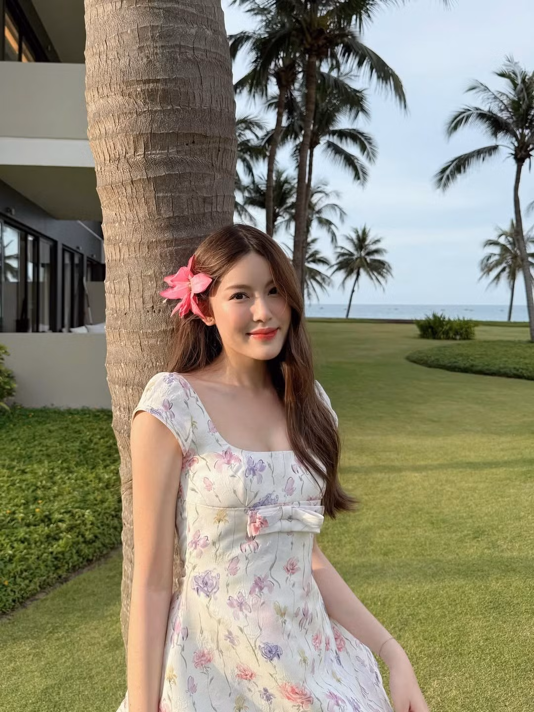 Bên cạnh đôi chân dài "cực phẩm", Tăng Mỹ Hàn vẫn giữ nguyên vẻ đẹp ngọt ngào, trong trẻo thường thấy. Nụ cười mỉm duyên dáng, ánh mắt nhẹ nhàng cùng bông hoa dâm bụt hồng cài trên tóc đã tạo nên một tổng thể hài hòa, tựa như một "nàng thơ" giữa khung cảnh xanh mát của hàng dừa và biển cả.