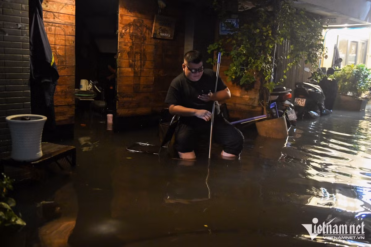 Chủ quán cà phê Hoàng Định cho biết, nước tràn vào quán, có thời điểm dâng hơn 60cm. Dù đã muộn nhưng anh vẫn ngồi chờ nước rút để dọn dẹp. Nhiều bàn ghế, vật dụng trong quán được kê lên cao để tránh ngâm lâu trong nước.
