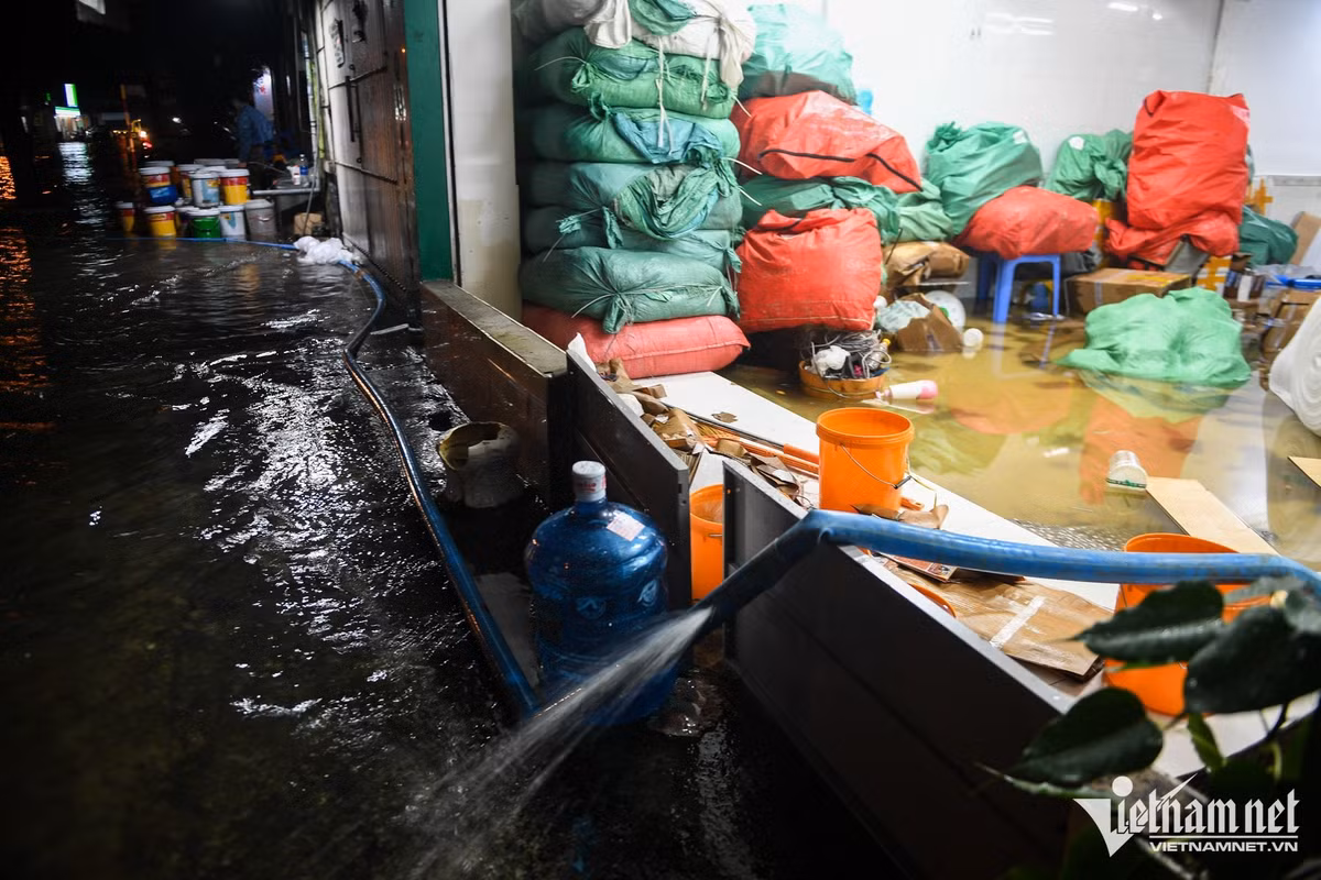 Đến 23h, sau khoảng 7 giờ kể từ khi mưa lớn, nước vẫn còn ngập khoảng 50cm. Nhiều hộ dân phải dùng máy bơm, tìm cách đẩy nước ra ngoài, đồng thời tranh thủ dọn dẹp, di chuyển đồ đạc để hạn chế thiệt hại.