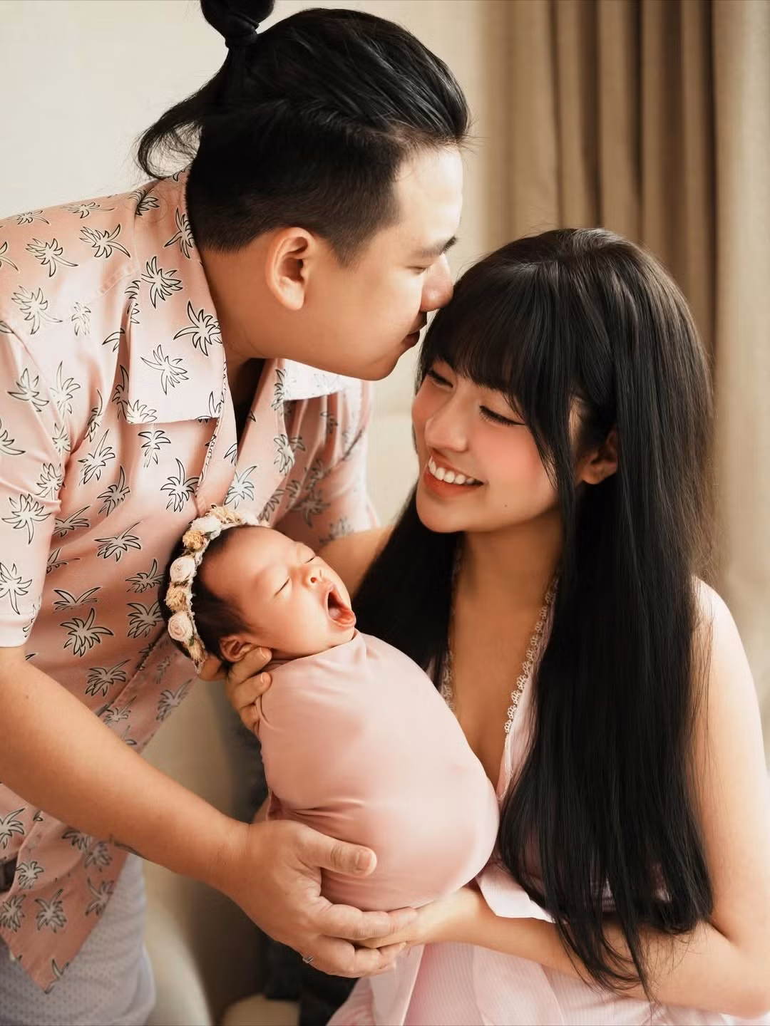Trong bộ ảnh, Trần Thanh Tâm và ông xã Mai Thiên Ân lựa chọn trang phục tông hồng pastel nhẹ nhàng, đồng điệu với chiếc khăn quấn màu hồng đất xinh xắn của con gái. (Ảnh: IGNV)