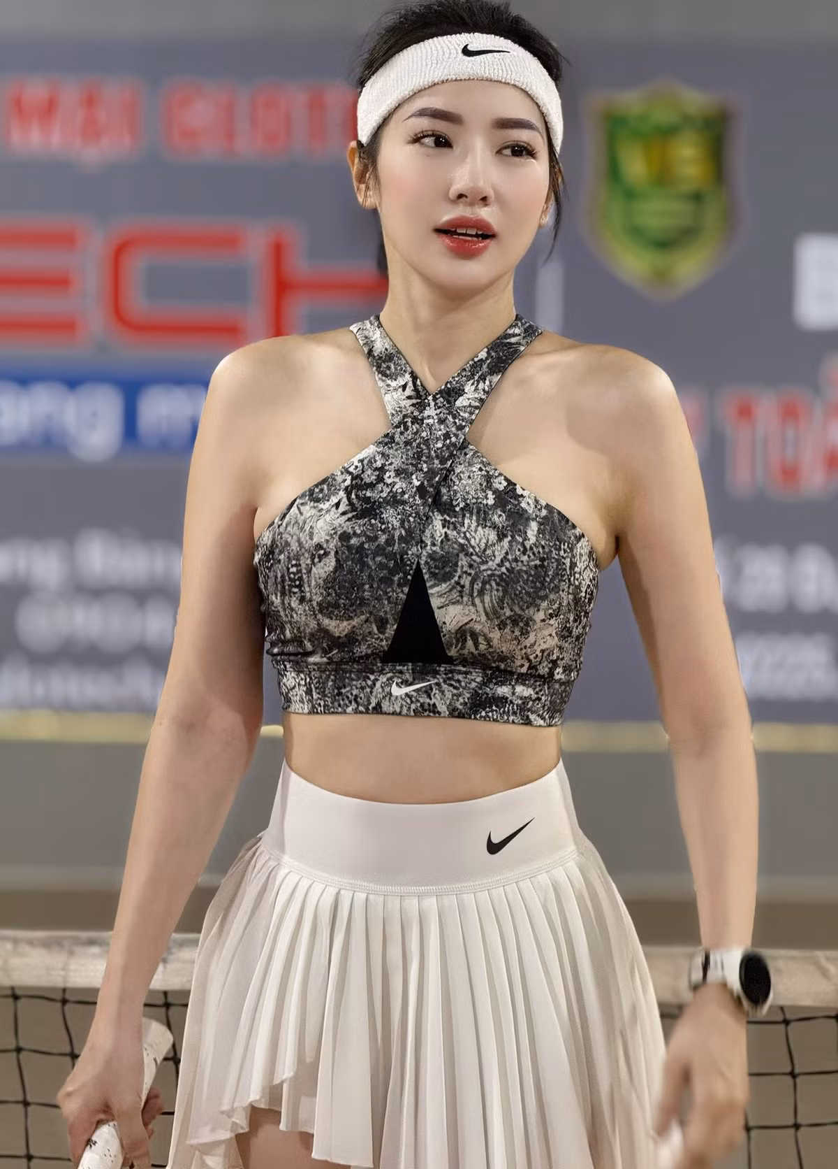Cô lựa chọn áo bra thể thao họa tiết xám đen độc đáo, với phần dây đan chéo tinh tế ở cổ, khoe trọn vòng eo săn chắc, kêt hợp chân váy tennis màu trắng xếp ly cạp cao, không chỉ tạo sự thoải mái khi di chuyển mà còn tôn lên đôi chân nuột nà.(Ảnh: FBNV)