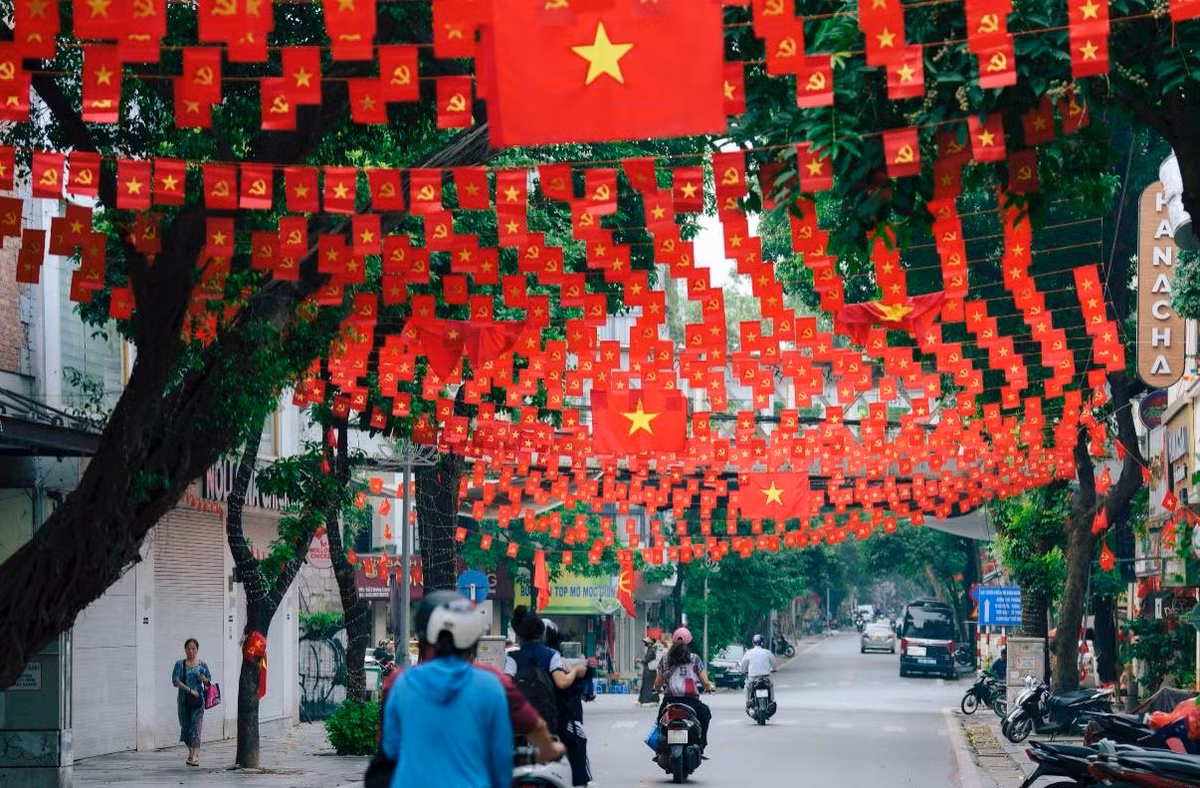 Những dải cờ đỏ nối tiếp nhau, đan xen giữa những tán cây xanh mát, tạo thành một "mái vòm" cờ rực rỡ. (Ảnh: Blog Của Rọt)