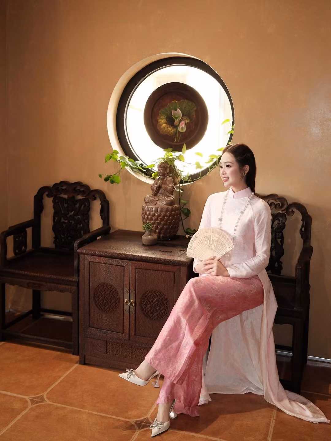 Cô khéo léo kết hợp cùng chuỗi vòng cổ ngọc trai dài, đôi bông tai đồng điệu và chiếc quạt giấy - những phụ kiện đặc trưng của phụ nữ Hà thành xưa, gợi lên nét đẹp của một "nàng thơ" khuê các. (Ảnh: IGNV)