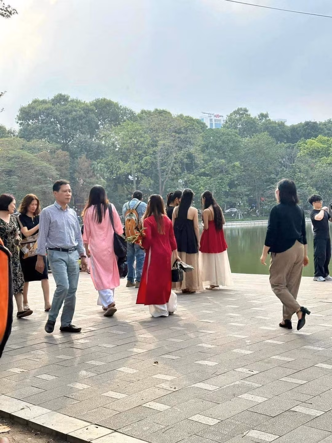 Những ngày này, không khí tại Hồ Gươm náo nhiệt hơn bao giờ hết, đặc biệt là những ngày cuối tuần. Từ những tà áo dài lụa thướt tha, áo ngũ thân cổ điển đến những bộ cánh rực rỡ sắc đỏ, hồng, cam... mang đậm không khí Tết.