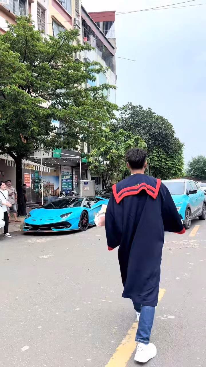Mới đây trên mạng xã hội xôn xao clip ghi lại cảnh một nam thanh niên mặc áo cử nhân, bước lên chiếc Lamborghini Aventador SVJ màu xanh dương nhạt. Chỉ trong thời gian ngắn, đoạn video đã nhanh chóng đạt được cả chục triệu lượt xem.
