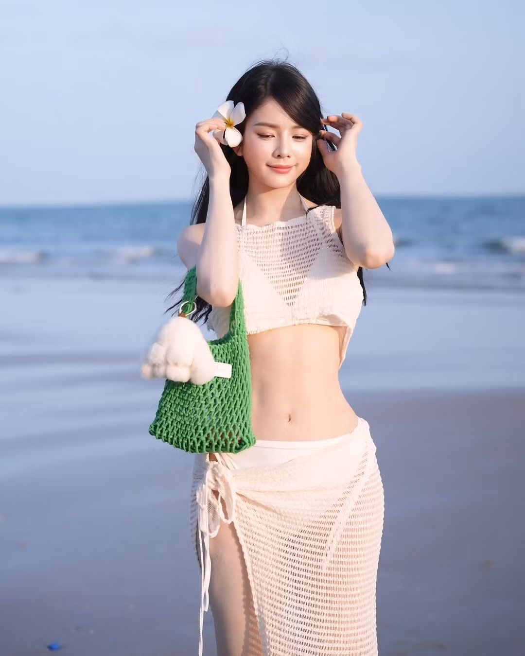 Trong loạt ảnh mới nhất, Mie tiếp tục khiến mạng xã hội dậy sóng với outfit trắng xuyên thấu, mix khéo léo cùng bikini bên trong và điểm xuyết bằng bông hoa đại cài tóc.