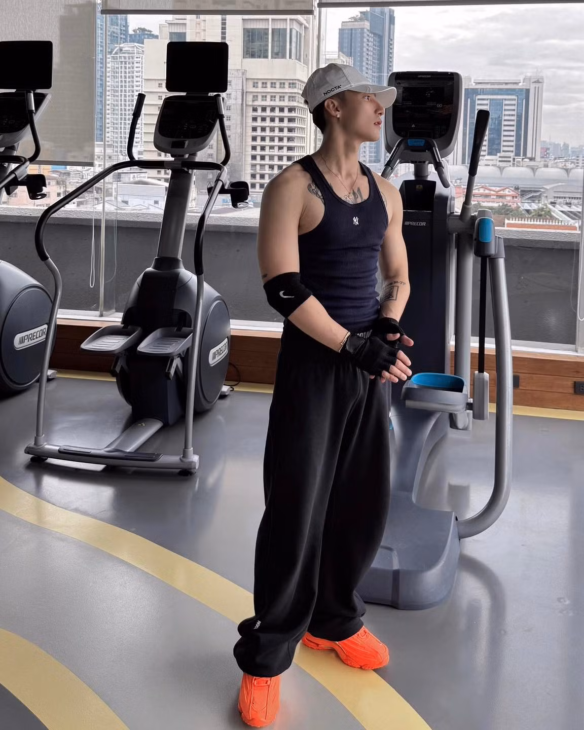 Anh lựa chọn trang phục đơn giản nhưng vô cùng cá tính: áo ba lỗ màu xanh navy khoe trọn bắp tay săn chắc, kết hợp cùng quần jogger rộng thùng thình màu đen.