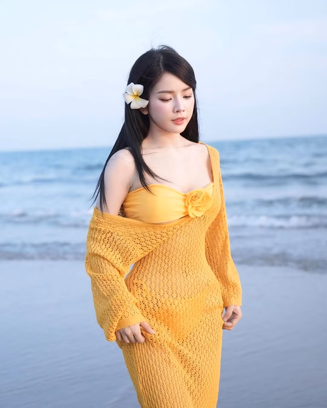Trong một lần khác, Mie gây ấn tượng với bộ váy lưới vàng rực – tông màu chói chang như ánh nắng mùa hè. Chiếc váy được đan móc thủ công với chất liệu nhẹ tênh, vừa tạo hiệu ứng thị giác quyến rũ vừa tôn lên nước da trắng bật tông của cô nàng.