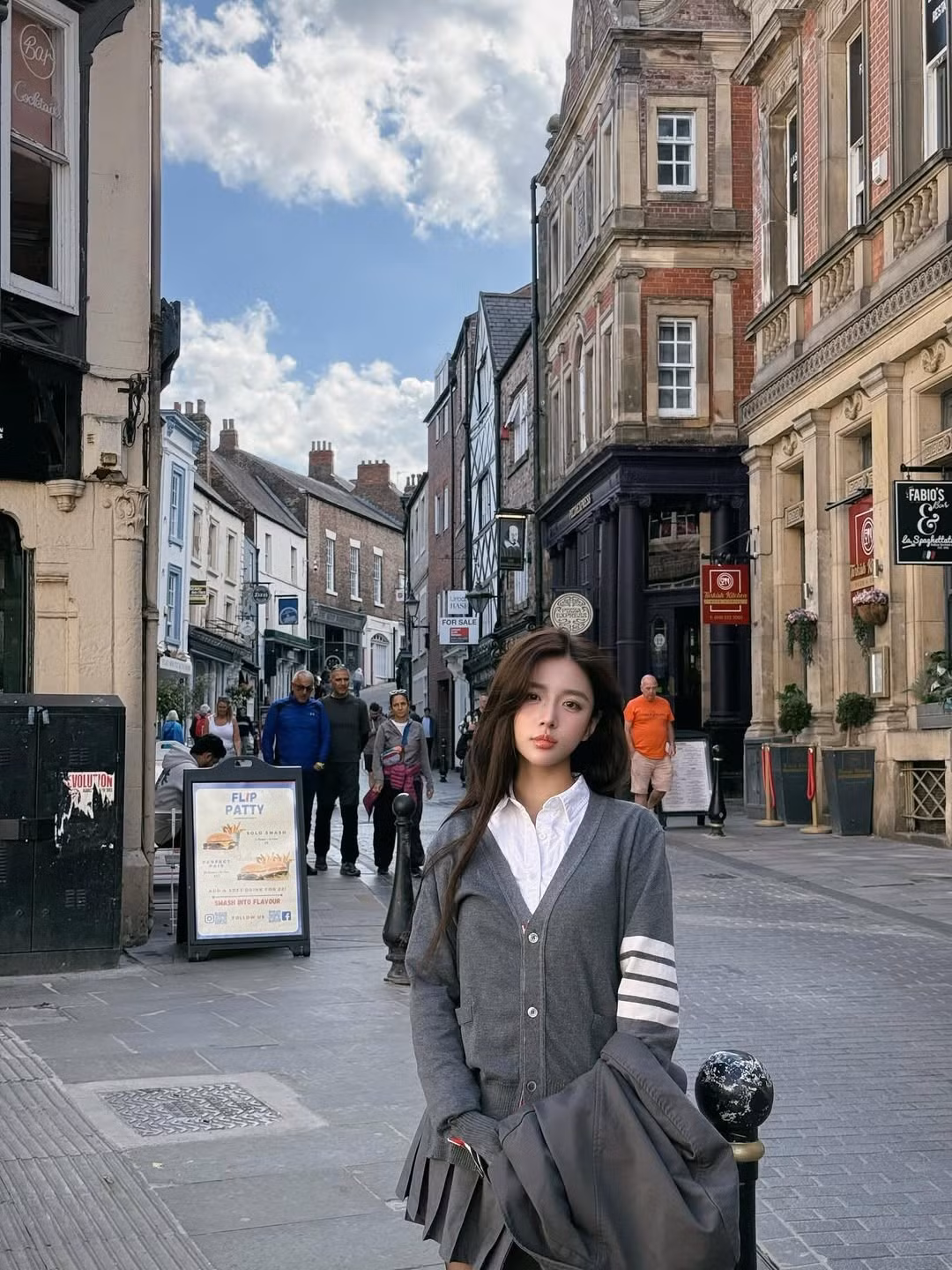 Cô diện trang phục đơn giản nhưng tinh tế, kết hợp áo sơ mi trắng cùng cardigan và blazer, tạo nên vẻ ngoài thanh lịch và hiện đại. (Ảnh: IG @cas.naf)