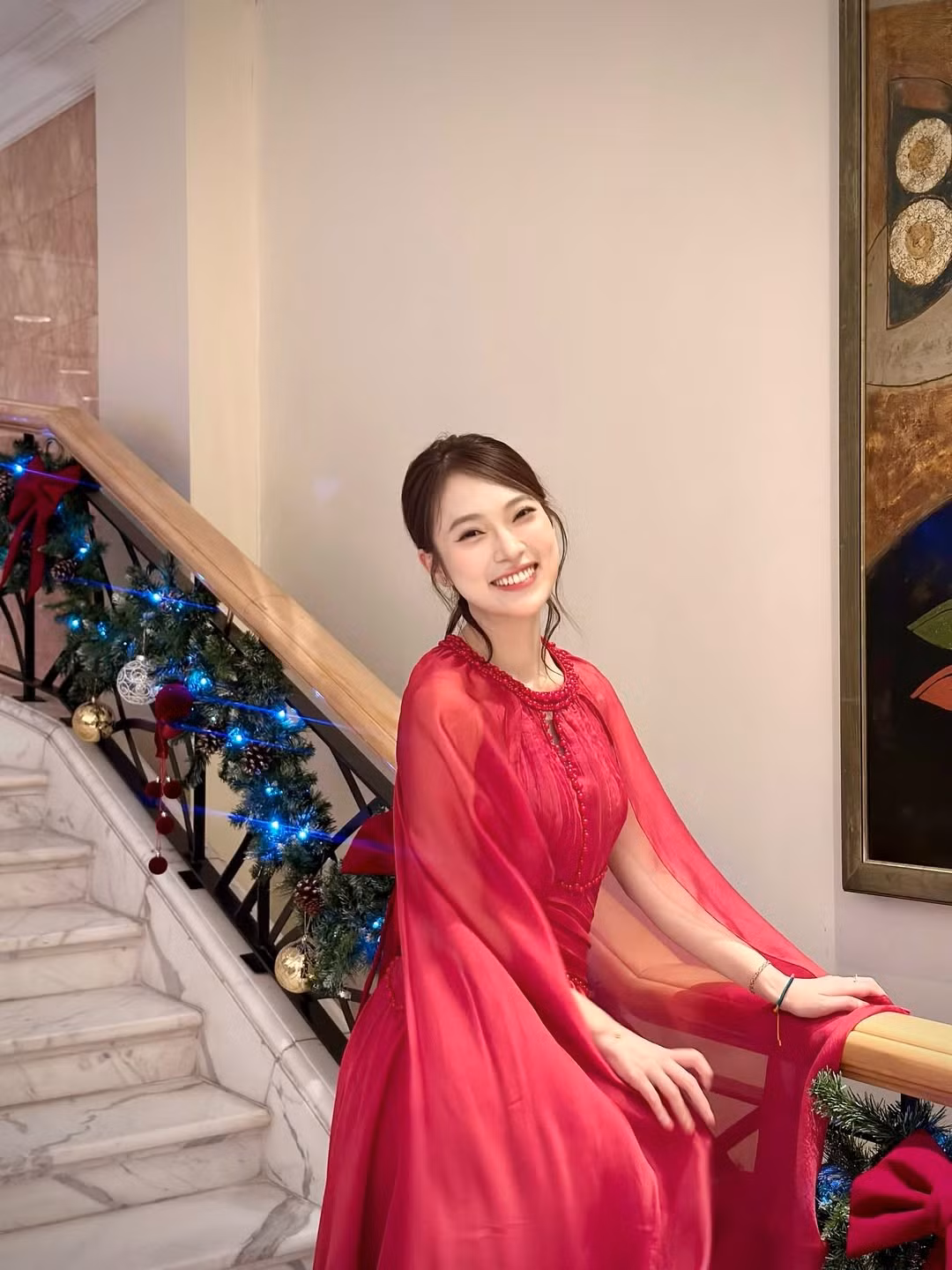 Bối cảnh của bộ ảnh là một không gian sảnh lớn với cây thông Noel khổng lồ được trang trí cầu kỳ bằng những quả cầu đỏ - vàng và ánh đèn led lấp lánh. (Ảnh: IGNV)