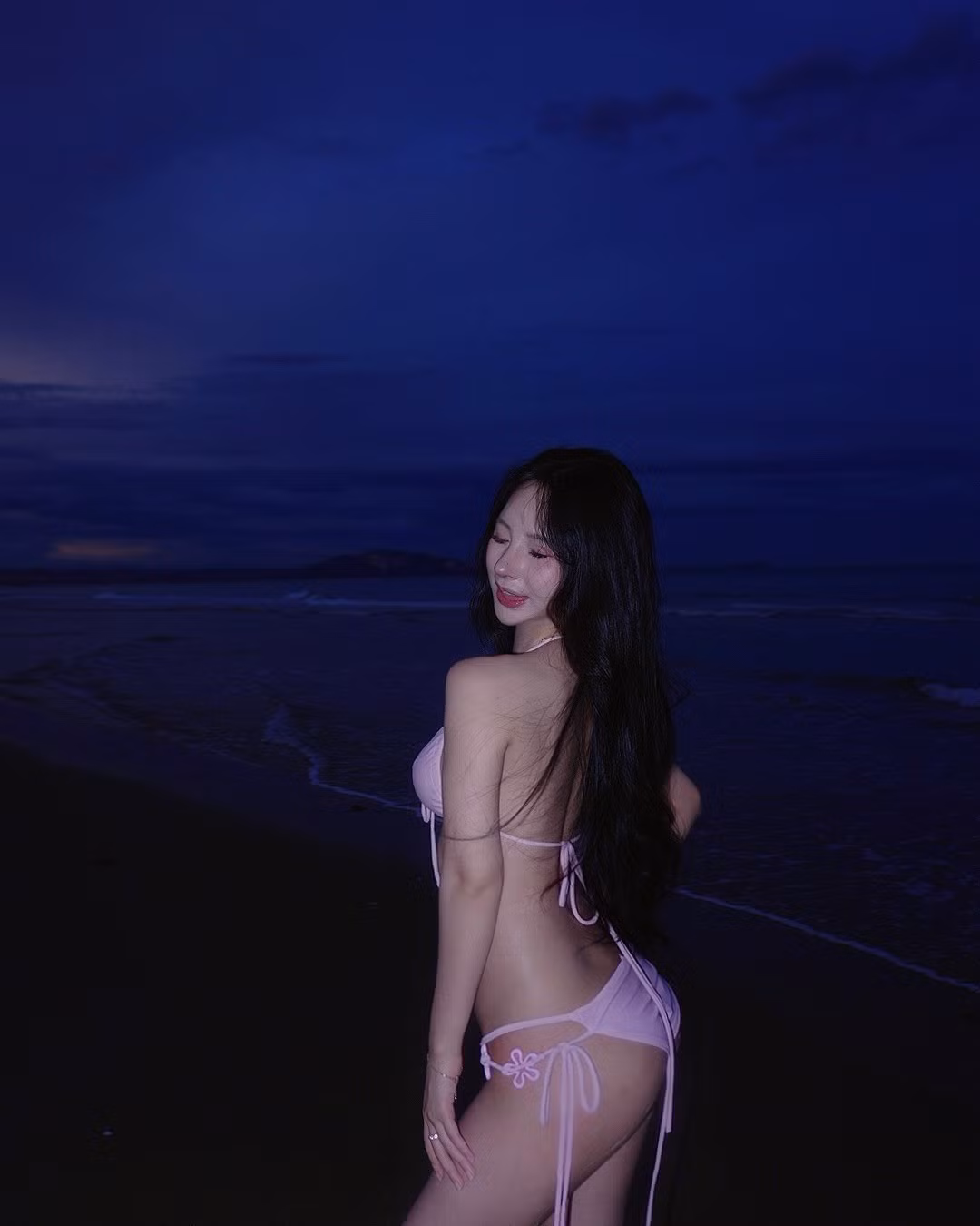 Uyên Ni tự tin tạo dáng trên nền cát mịn và những con sóng vỗ nhẹ vào bờ. Mái tóc đen dài bồng bềnh xõa tự nhiên, kết hợp với lối trang điểm nhẹ nhàng nhưng vẫn làm nổi bật đôi mắt to tròn, có hồn và bờ môi căng mọng.