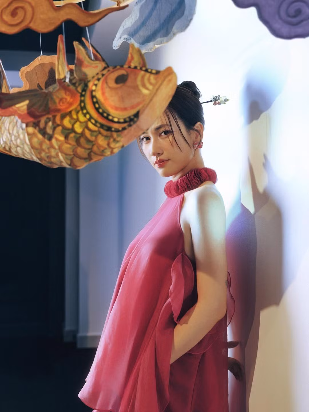 Nữ diễn viên diện một chiếc áo yếm cổ chun bèo nhún phồng rực rỡ, kết hợp cùng quần lụa ống rộng màu xanh tím than, tạo nên sự đối lập màu sắc đầy mạnh mẽ và thời thượng.