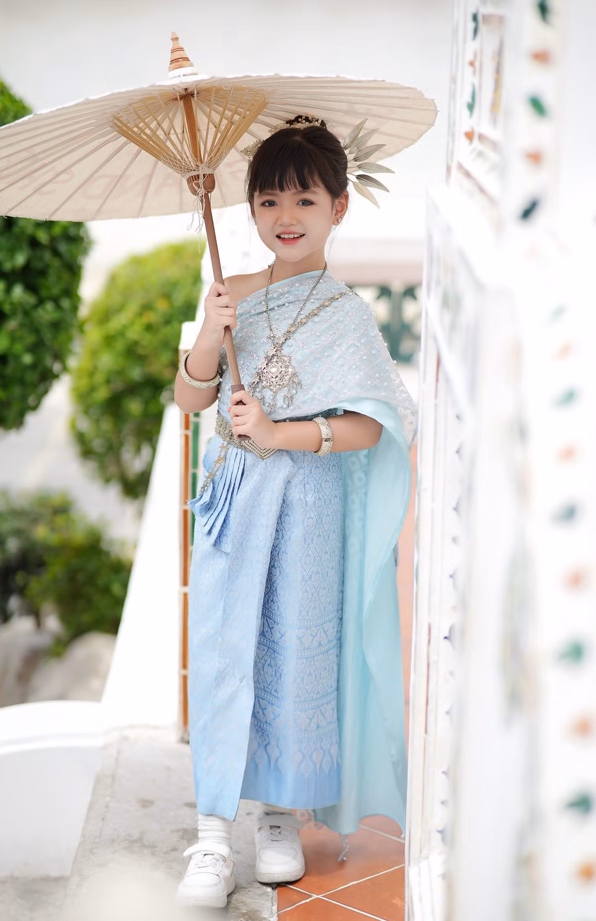 Cô bé diện bộ Thai-Chut (trang phục truyền thống Thái Lan) với tông màu xanh ngọc và xanh dương nhạt vô cùng mát mắt và trang nhã. (Ảnh: FBNV)