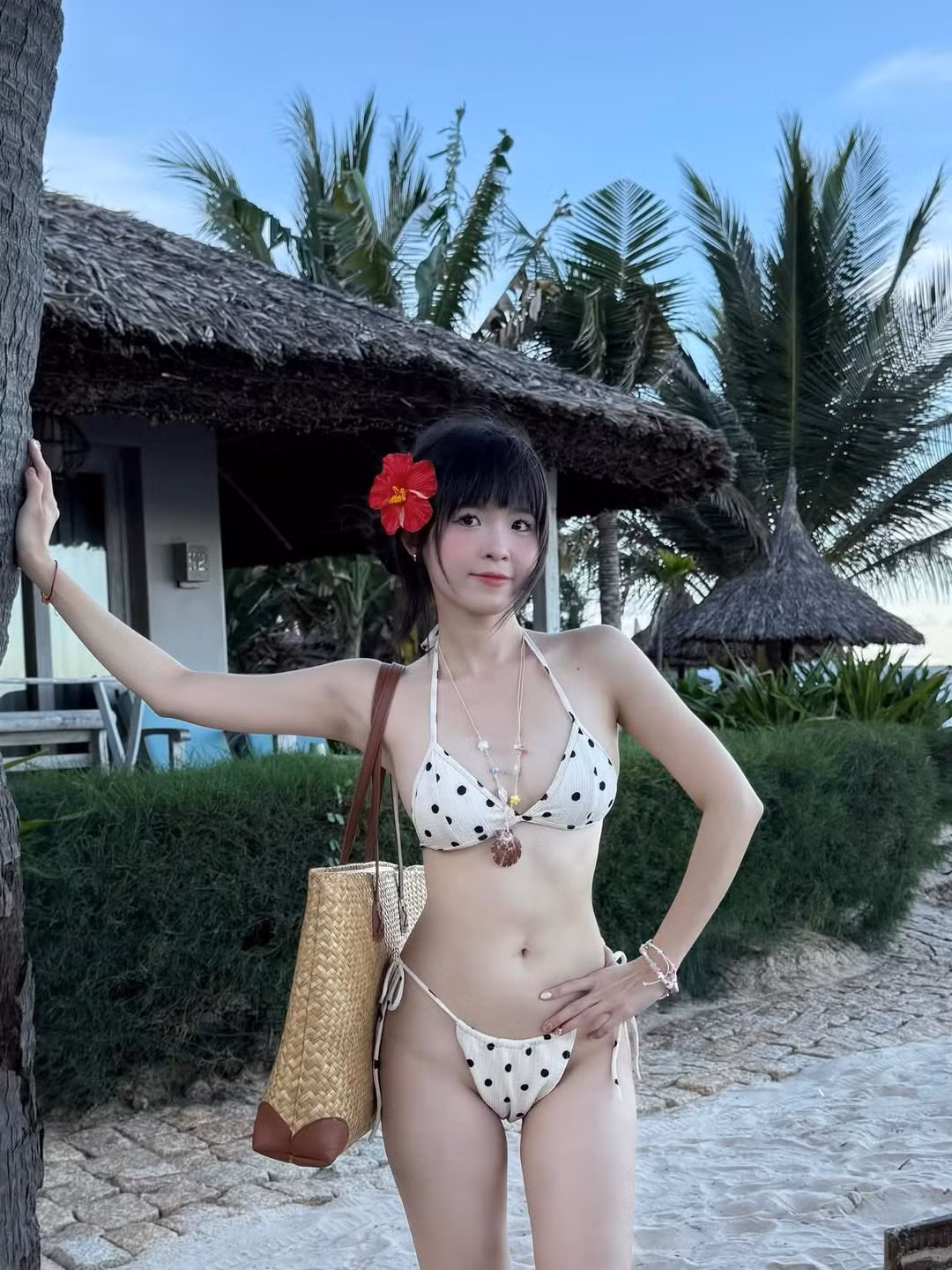 Điểm nhấn trên tổng thể trang phục còn là chiếc túi cói bản lớn, cùng những chuỗi vòng cổ và vòng tay hạt cườm đầy màu sắc, tạo nên một phong cách đi biển vừa sành điệu, vừa phóng khoáng.