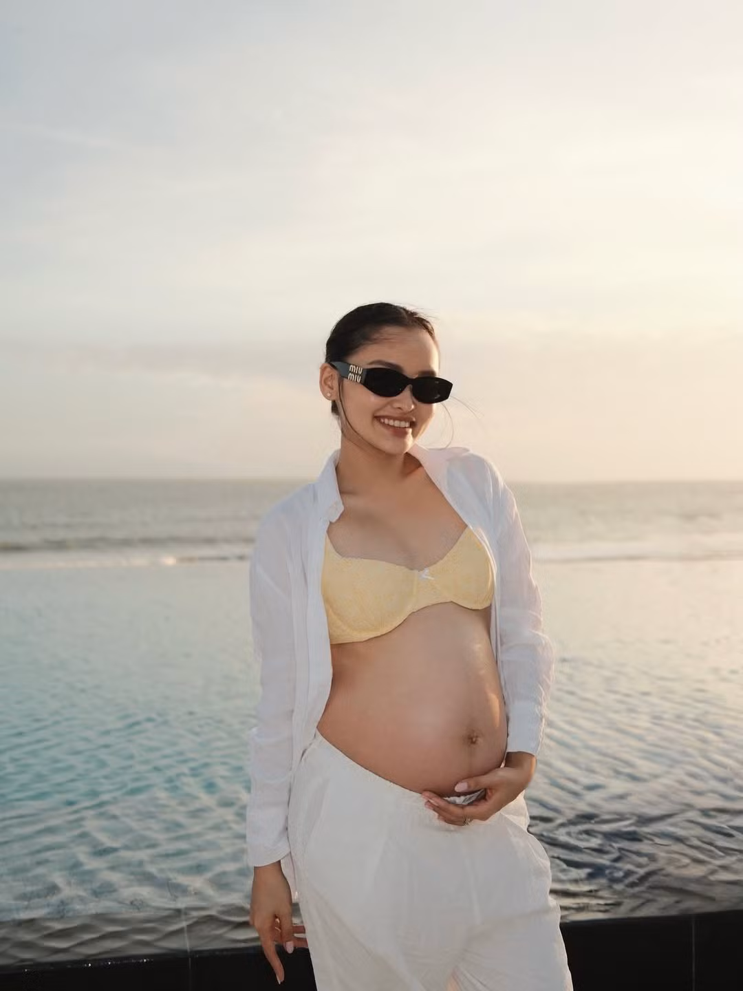 Trong bộ ảnh mới, Linda Ngô tự tin diện bộ bikini màu vàng nhạt nhẹ nhàng, kết hợp khéo léo cùng áo sơ mi trắng khoác ngoài và quần ống rộng ton-sur-ton. (Ảnh IGNV)