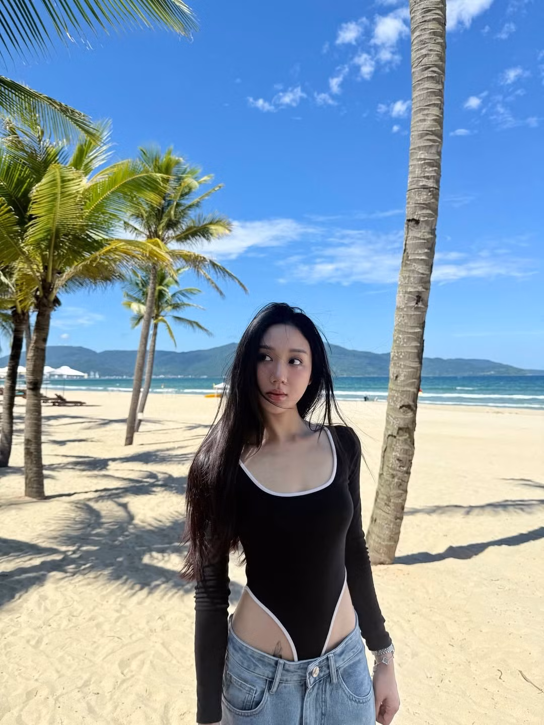Chiếc bodysuit đen viền trắng này có thiết kế khoét hông cực kỳ cao, phô diễn gần như trọn vẹn vòng eo săn chắc và đôi chân dài miên man của Mina Young. Đây là phong cách thời trang đang rất thịnh hành, giúp người mặc "hack" dáng tối đa. (Ảnh: IGNV)
