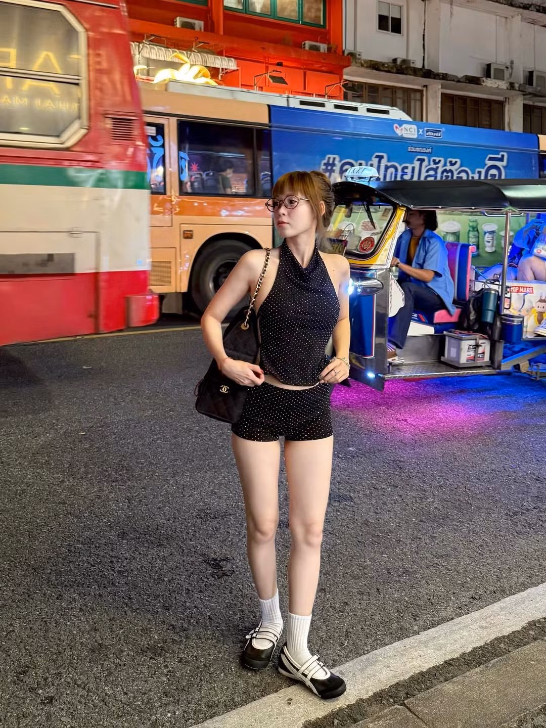 Cô nàng kết hợp trang phục với đôi giày thể thao cá tính, tất cổ cao màu trắng và một chiếc túi xách hàng hiệu có dây xích sang trọng. (Ảnh: FBNV)